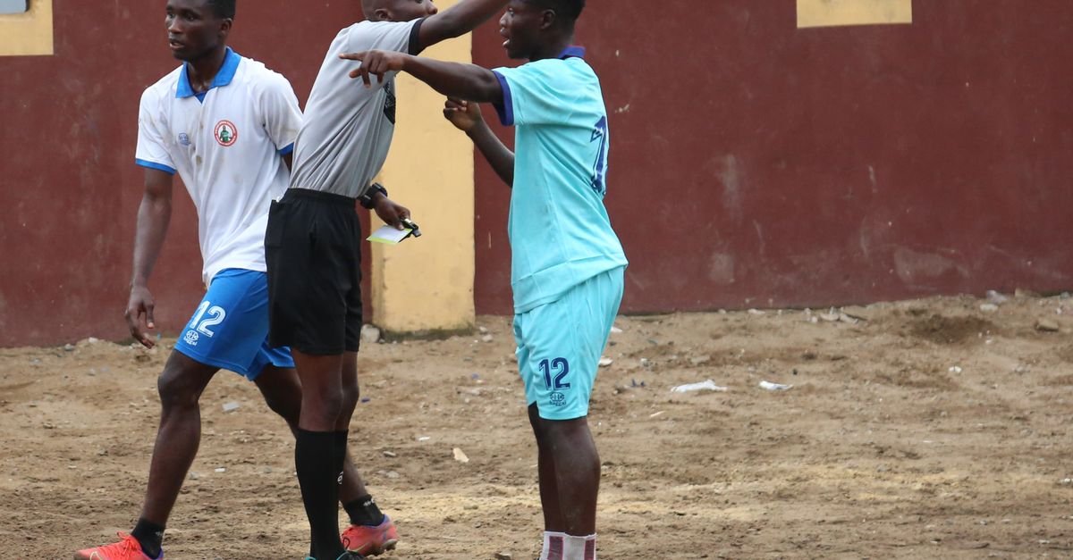 Soccer players and referee in heated discussion during a local match, highlighting sportsmanship.