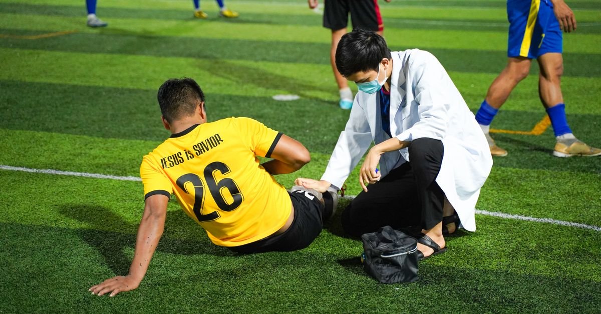 Soccer player receiving medical aid on the field for injury during a match.