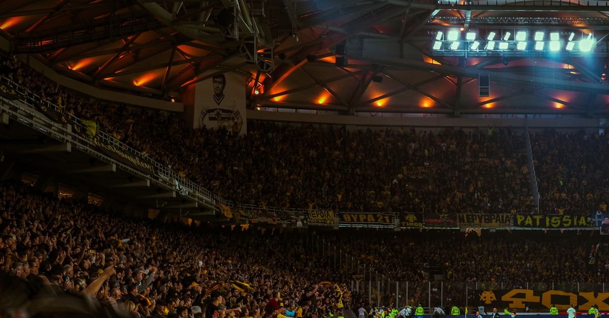 Exciting night soccer game with packed cheering fans and vibrant stadium lights.