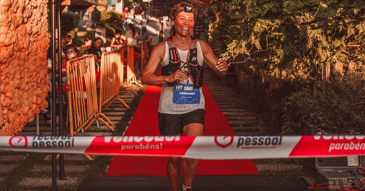 A joyful woman crossing the race finish line triumphantly outdoors.