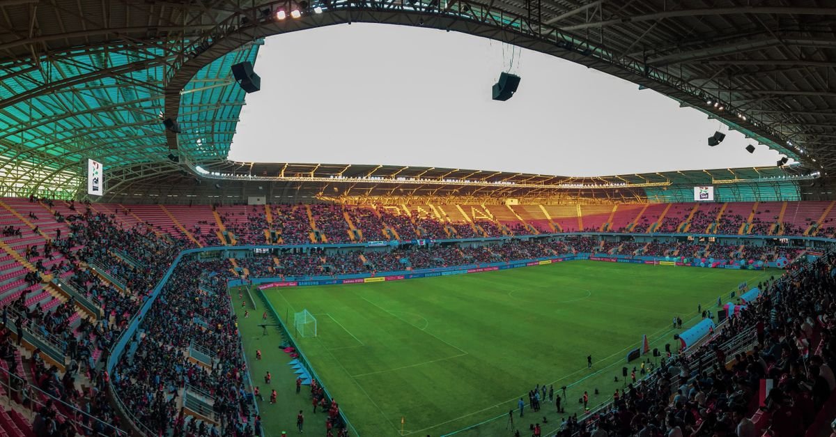 Panoramic view of a bustling soccer stadium filled with enthusiastic fans during a vibrant match.