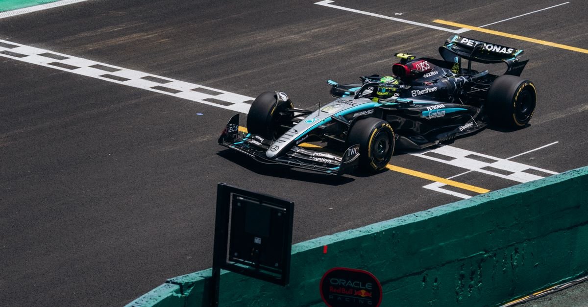 High-speed Formula 1 car crossing the finish line on a race track during the day.