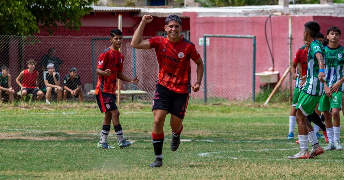 Teen soccer player celebrates on the field during an outdoor match game.