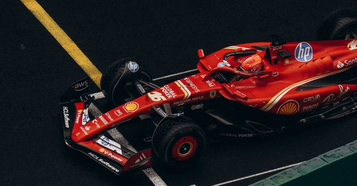 Dynamic shot of a red Formula One car racing on a track, showcasing speed and precision.