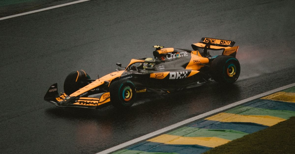 A Formula 1 car speeds around a wet track during an intense race, highlighting precision and speed.
