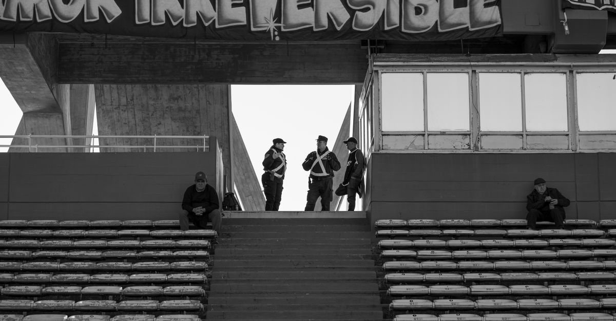 Black and white photo of a stadium grandstand in Córdoba, Argentina, with police presence.