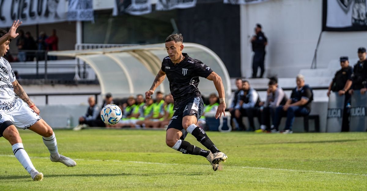 Soccer players in action during a competitive match on a sunny day.