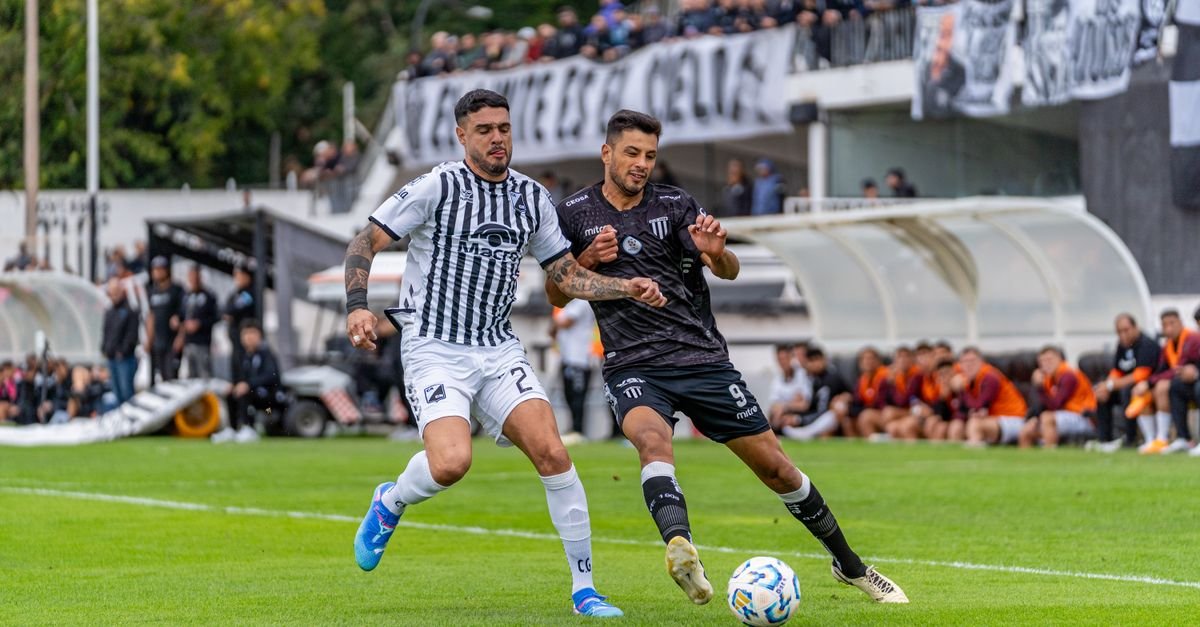Two soccer players in action during a competitive match outdoors.