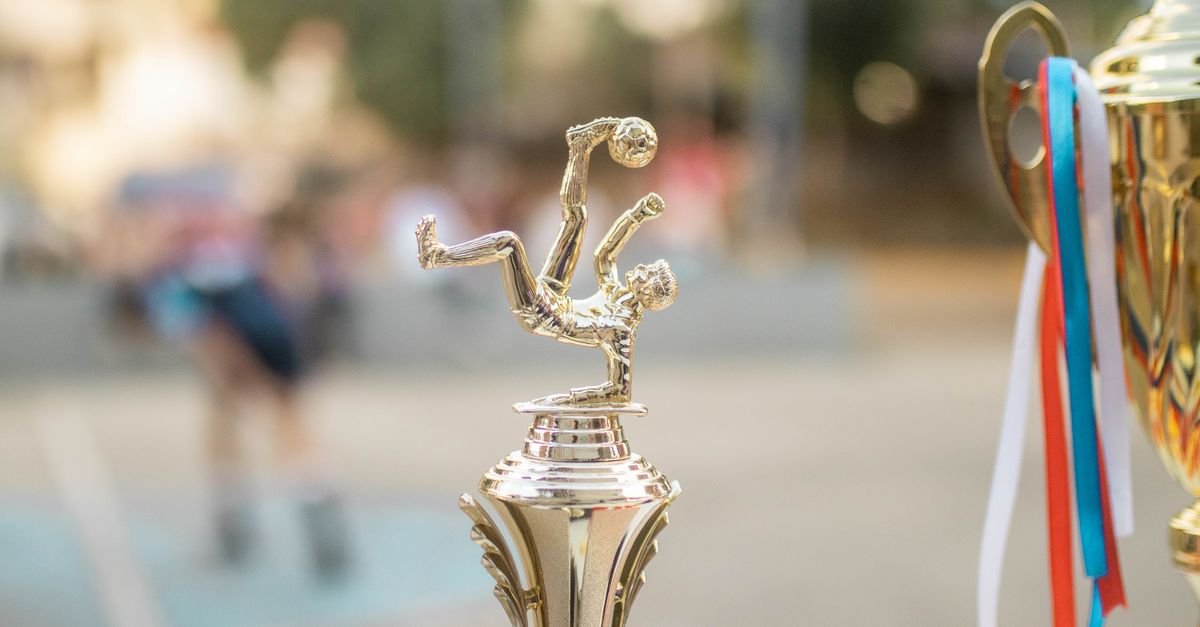 Golden football trophy with ribbons on display, capturing the essence of victory and sportsmanship.