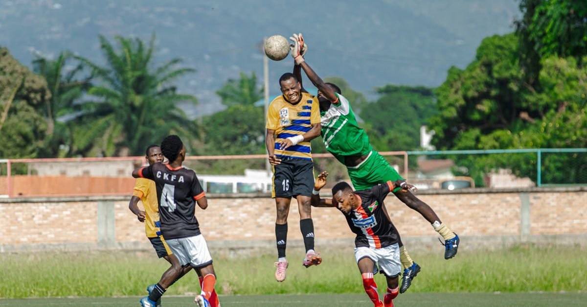 Intense soccer match with players competing to head the ball, showcasing skill and athleticism.