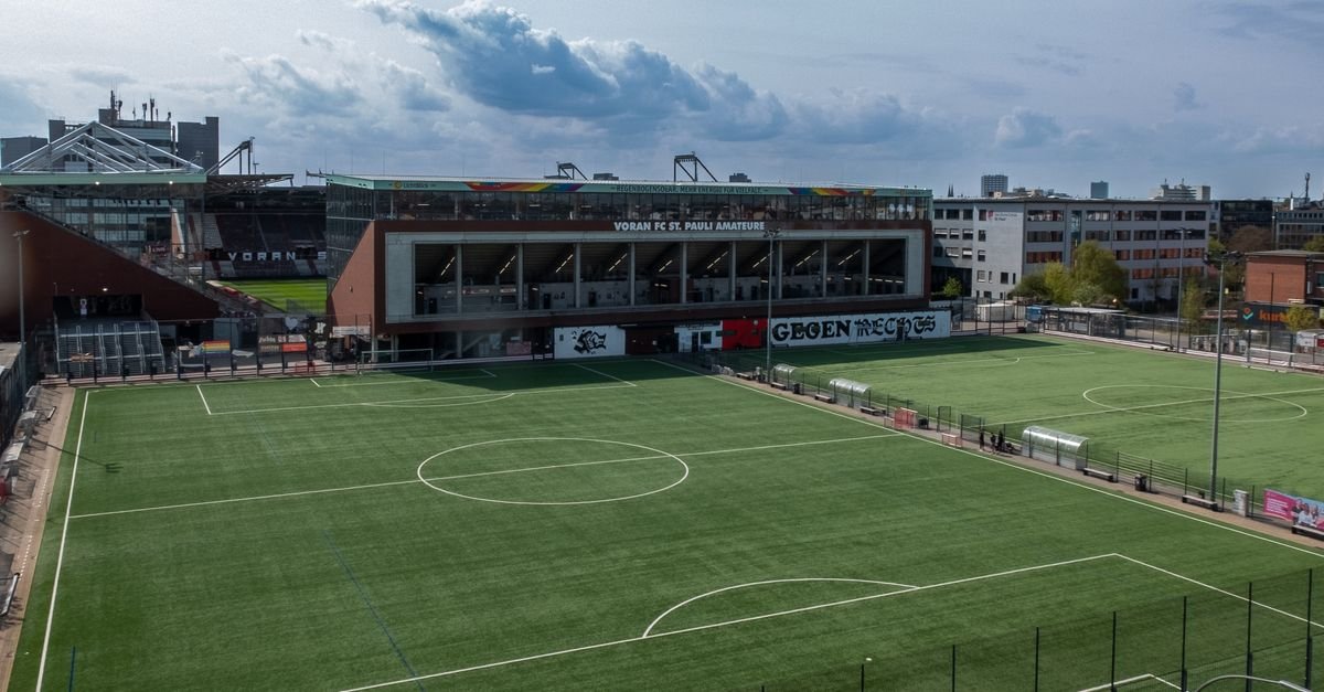 An aerial view of an empty soccer field and stadium in the city.