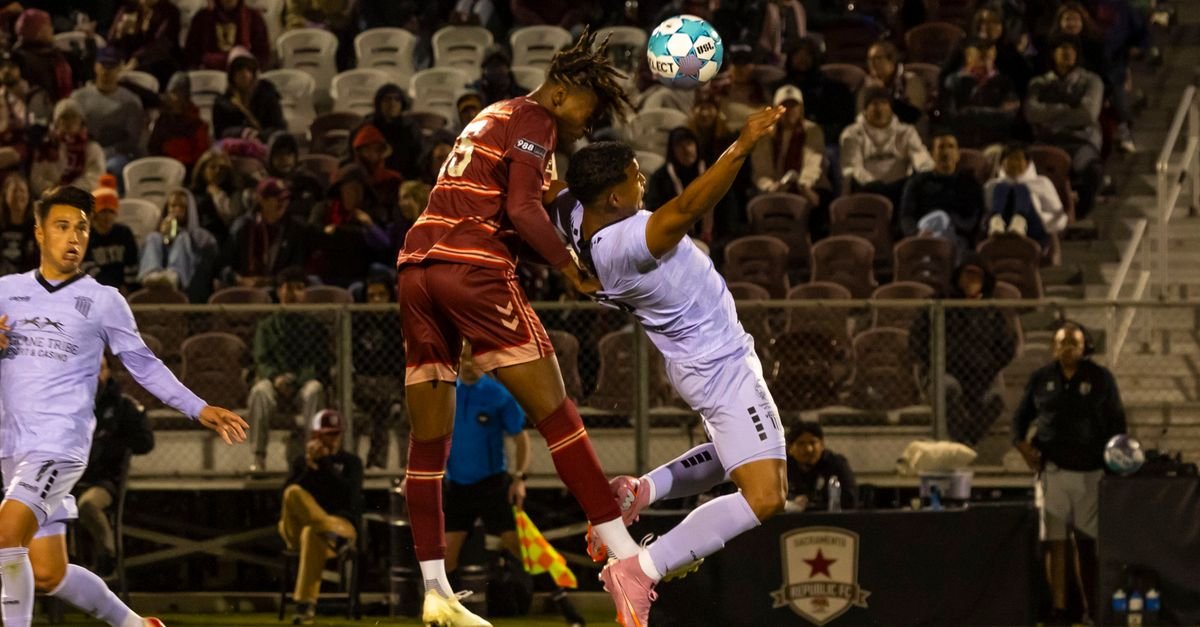Action-packed soccer match capturing a player mid-air going for a header.