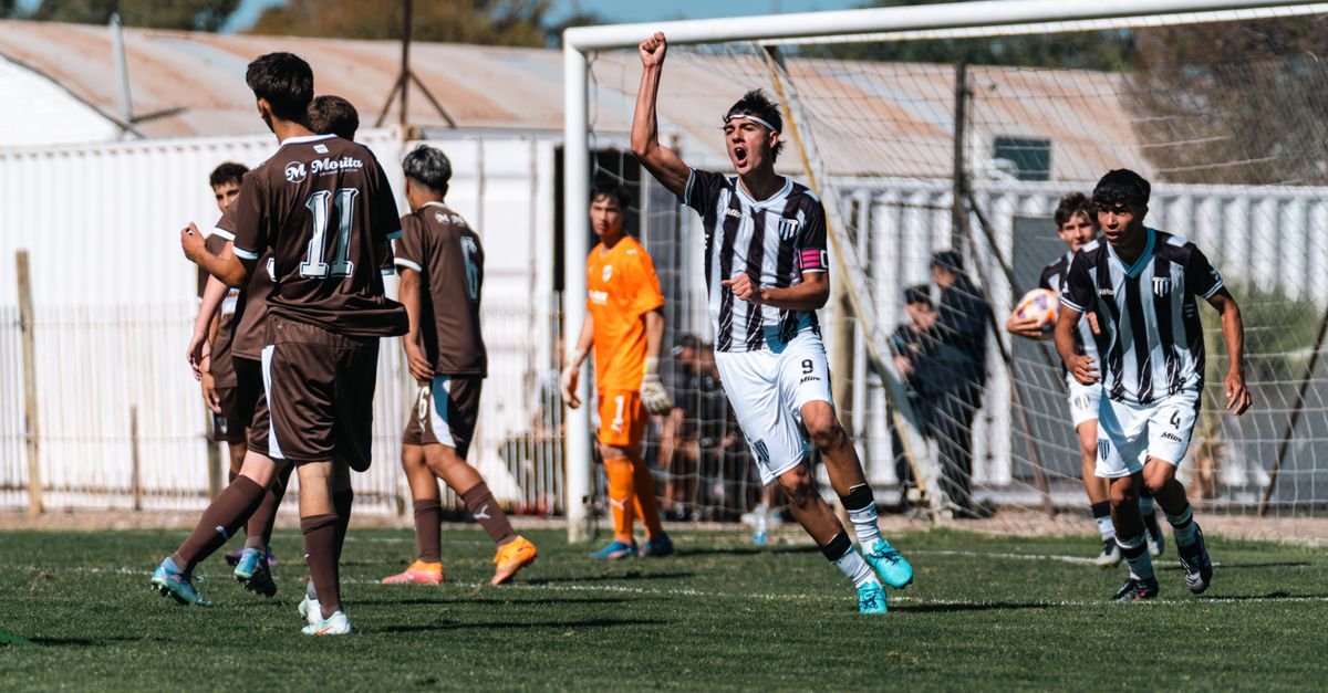 Teen soccer player celebrates scoring a goal during an intense youth match.