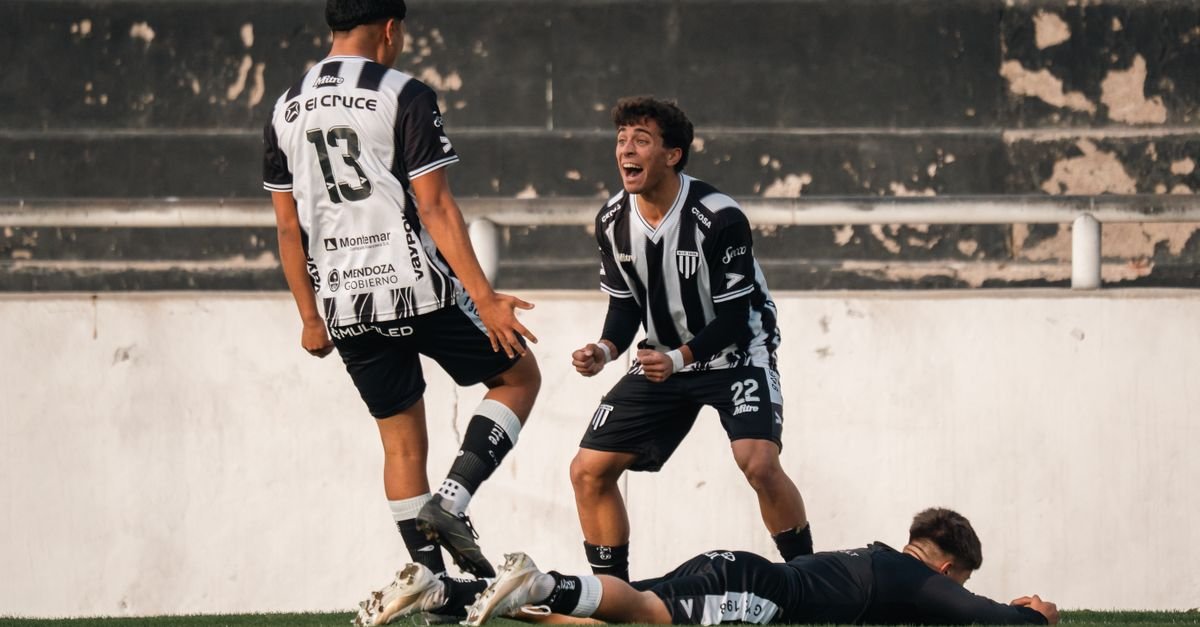 Football players in black and white jerseys celebrate a goal on the field.