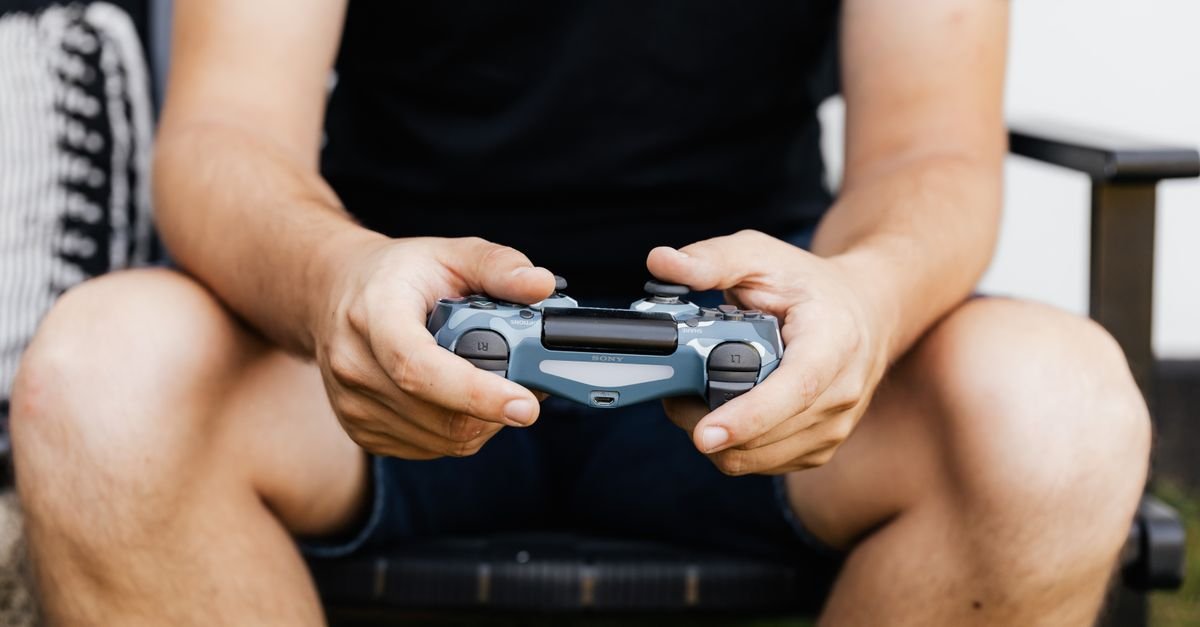 Close-up of hands holding a wireless gaming controller, perfect for tech enthusiasts.