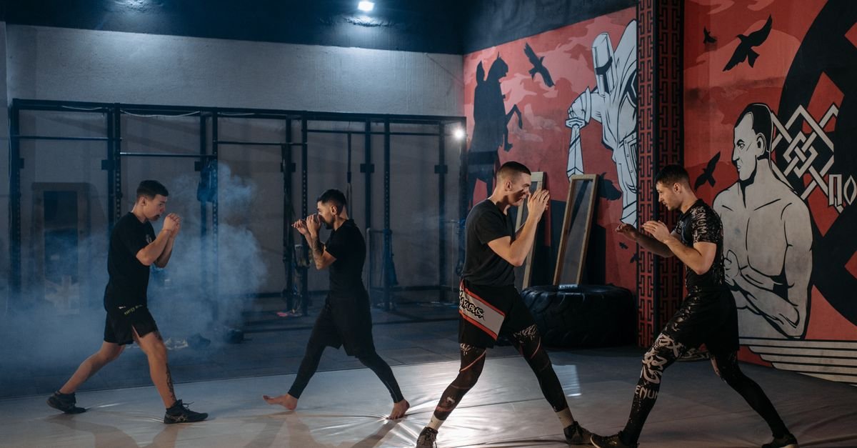 Group of men engaging in MMA sparring and training in a gym setting.