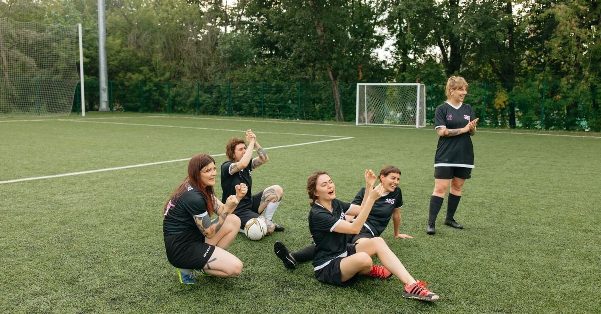 A women's soccer team celebrating joyfully on the field. Team spirit and sportsmanship.